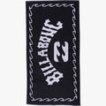 Black Billabong Arch Beach Towel with a white logo and wavy border, made from soft terry cloth, in a flat-lay view.