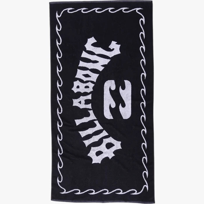 Black Billabong Arch Beach Towel with a white logo and wavy border, made from soft terry cloth, in a flat-lay view.