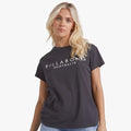 Blonde woman wearing an off-black Billabong Serenity short sleeve tee, presented in a casual, studio shot.