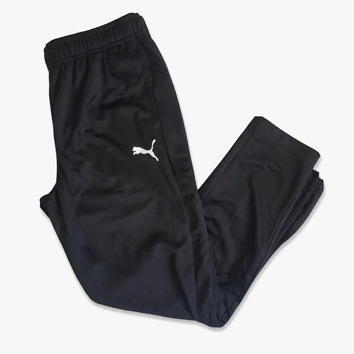 Black Puma Boys Za track pants, folded and displaying the white Puma logo, suitable for athletic wear or casual comfort.