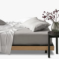 Silver Cotton Co 400 thread count queen fitted sheet on a bed, paired with white sheets and pillows, viewed from the side.