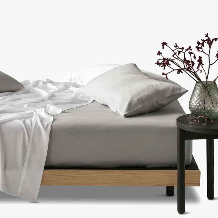 Silver Cotton Co 400 thread count queen fitted sheet on a bed, paired with white sheets and pillows, viewed from the side.
