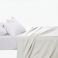Cotton Co 400 Thread Queen Flat Sheet in white, displayed on a bed with two white pillows.