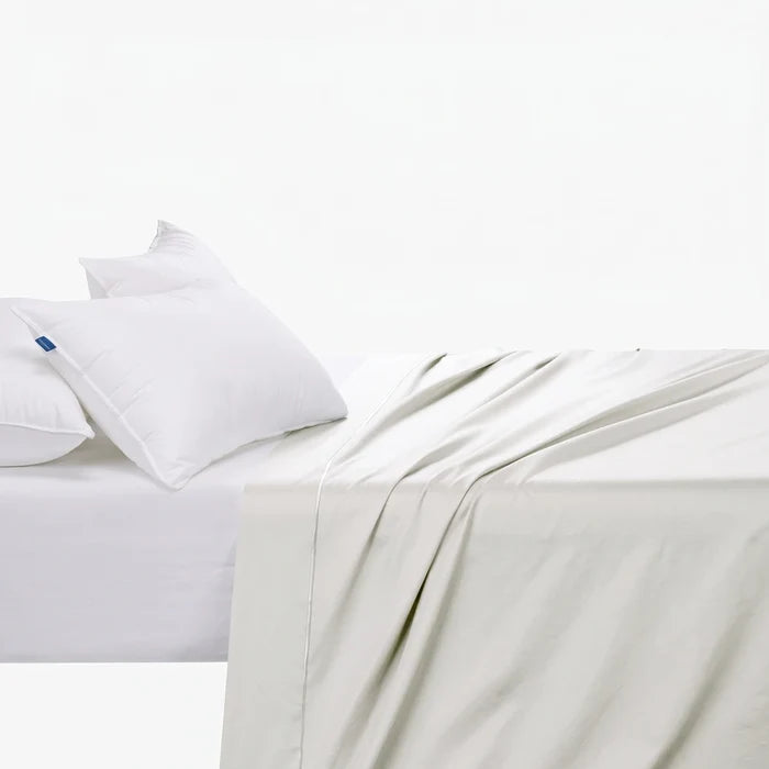 Cotton Co 400 Thread Queen Flat Sheet in white, displayed on a bed with two white pillows.