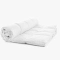 White Cotton Co Luxury 100% Cotton Queen Inner duvet, partially rolled, showcasing its plush quilted design.