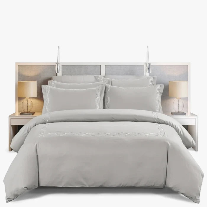 Light gray 300 thread count King duvet cover set with intricate white embroidery on a neatly made bed.