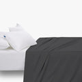 Black Cotton Co T400 double fitted sheet with extra depth, draped over a bed with two white pillows.