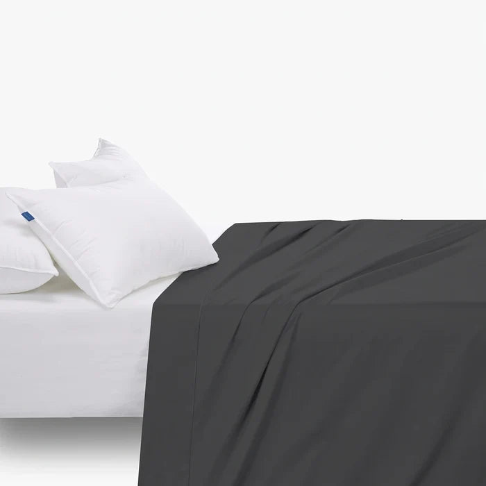 Black Cotton Co T400 double fitted sheet with extra depth, draped over a bed with two white pillows.