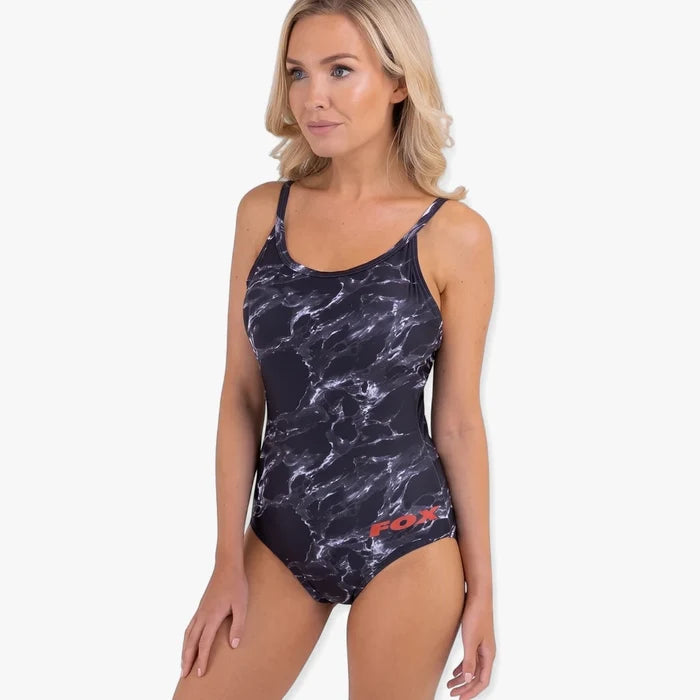 Blonde woman wearing a Fox Womens Karrera Full Costume black and white marble print one-piece swimsuit, side view.