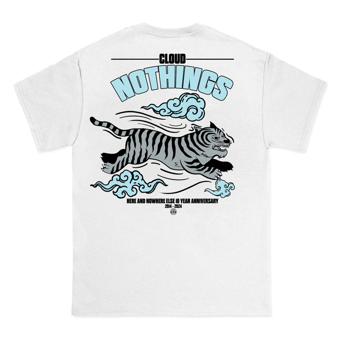 White Gildan Heavy t-shirt by Cloud Nothings, with a leaping black-striped tiger, blue clouds, and text: “CLOUD NOTHINGS” and “HERE AND NOWHERE ELSE 10 YEAR ANNIVERSARY 2014–2024.”.