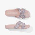 A pair of Holster Womens Kaylee sandals, featuring beige soles and sparkly silver glitter criss-cross straps, presented in a