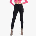 Black Sissy Boy high waist slim leg cargo pants with side pockets on a standing model wearing a pink crop top and sparkly